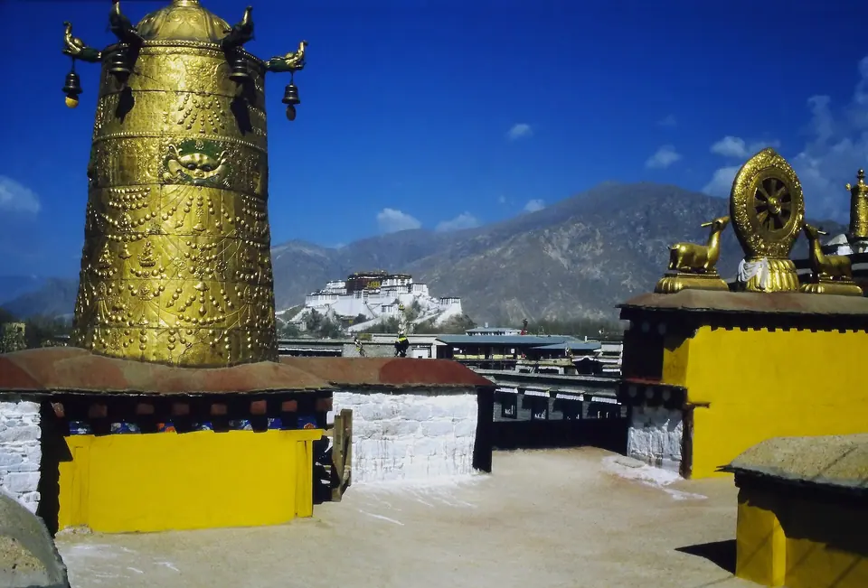 Golden roof of the Jokhang Temple in Lhasa with the Potala Palace beyond