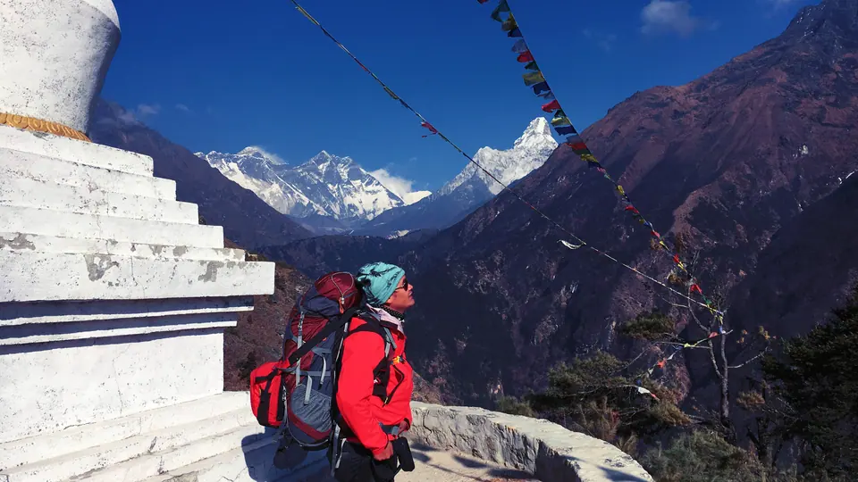 Trekker at a stupa above the Khumbu with Everest and Ama Dablam in view